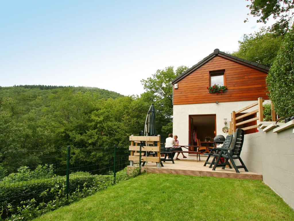 Casa con terraza con mesa y sillas en Cottage with a terrace and a view of the valley, en Aywaille