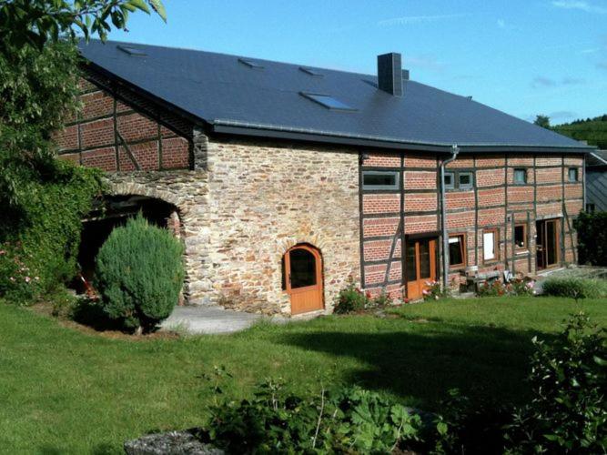 ルデュにあるSpacious holiday home with private gardenの黒屋根の大きなレンガ造りの家