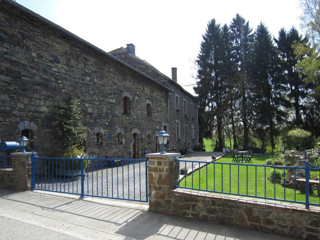 ein blauer Zaun vor einem Steingebäude in der Unterkunft holiday home in typical Ardennes style in Bérisménil