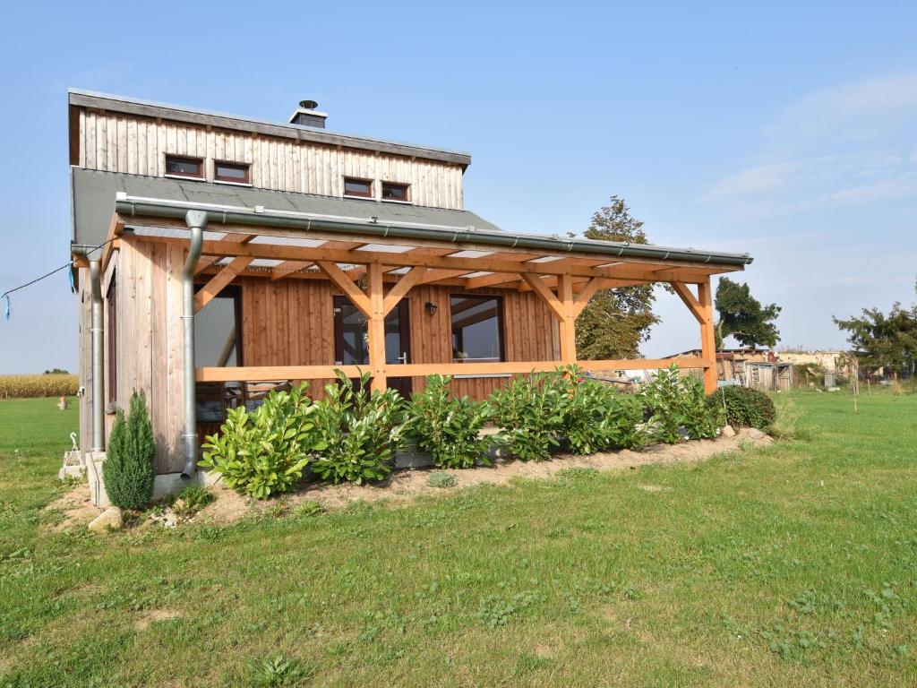 ein Haus mit Holzkonstruktion auf einem Feld in der Unterkunft Enchanting Holiday Home in Ruhn near the Sea in Rühn