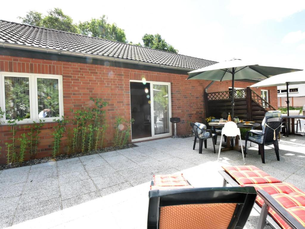 a patio with a table and chairs and an umbrella at Country holiday home in Damshagen with sauna in Damshagen