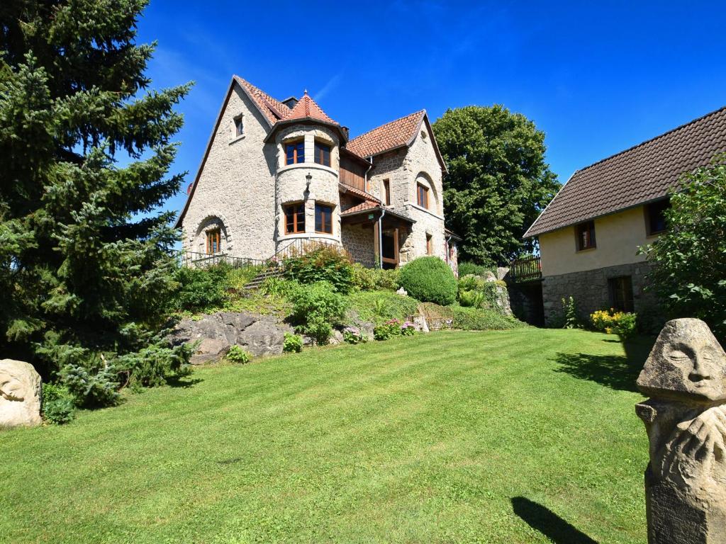 ein Haus auf einem Hügel mit einem Rasenplatz in der Unterkunft WunderVilla in Hesse near the forest in Vöhl