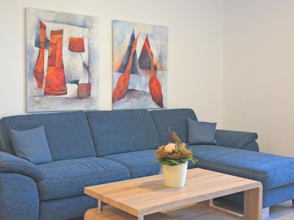 a blue couch in a living room with a coffee table at Ferienwohnung in Madfeld nahe Wald in Madfeld