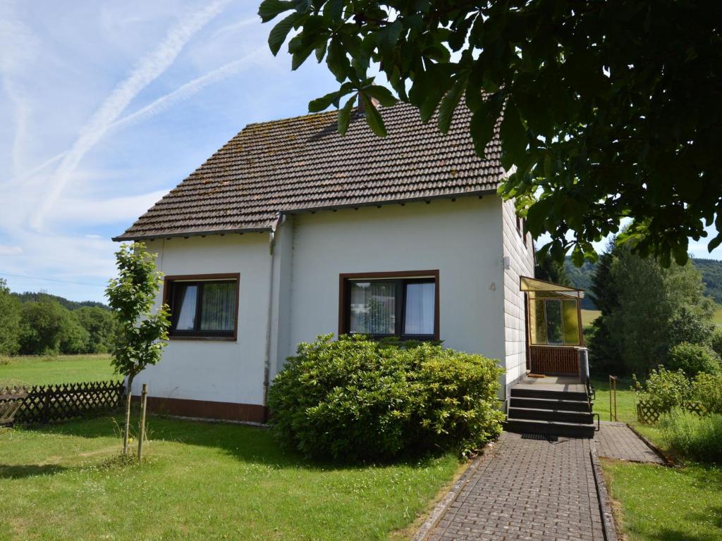 a small white house with a brick walk at Cozy Holiday Home in Wallenborn with Garden in Wallenborn