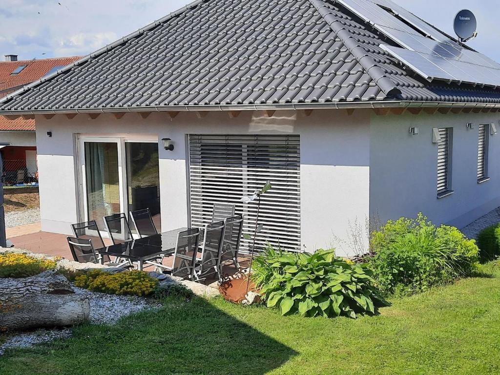 una casa con sillas en el patio en Detached holiday home in an idyllic quiet location, en Kleinwinklarn