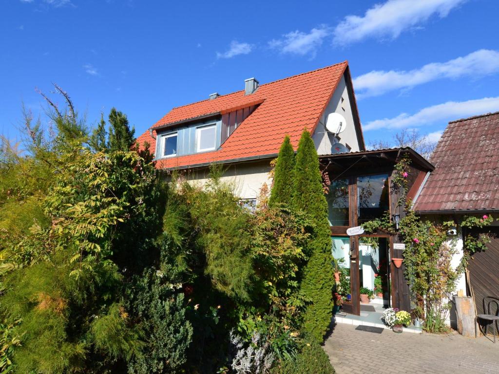 une maison avec un toit rouge et quelques arbres dans l'établissement Apartment in the middle of Franconian Switzerland, à Kunreuth
