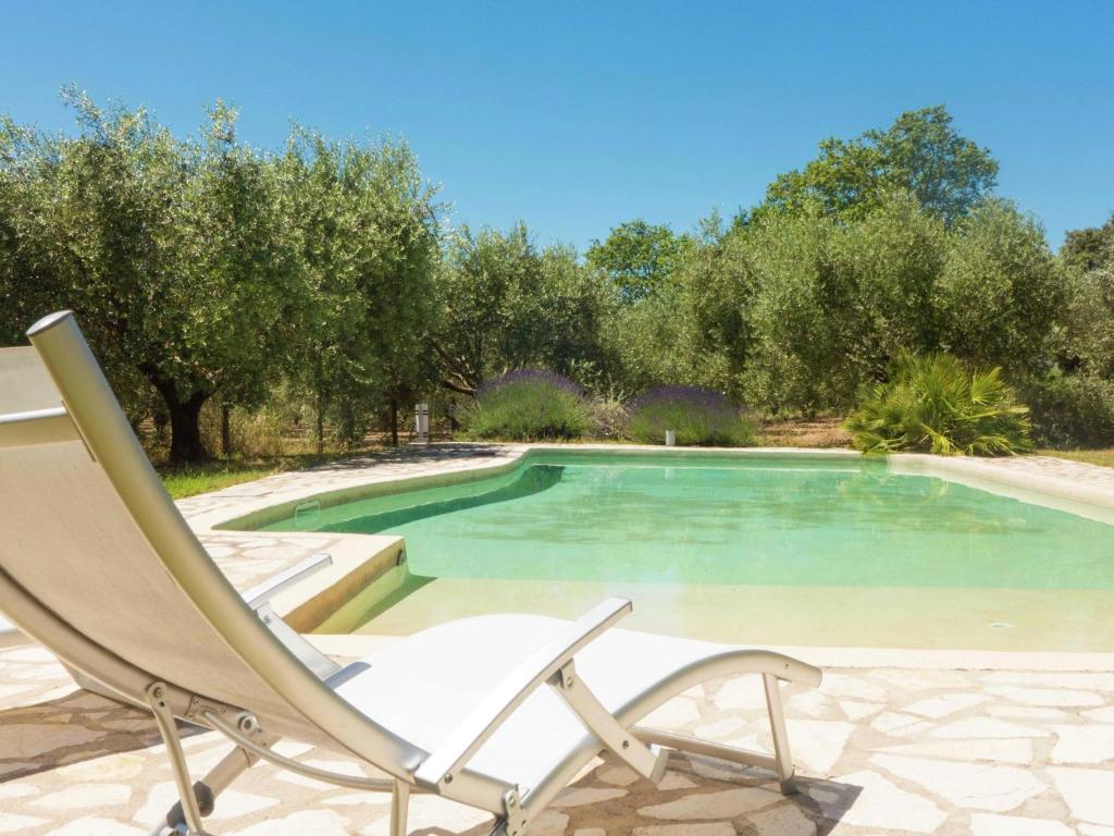 una silla sentada junto a una piscina en Spacious 6 person villa with pool, en Autignac