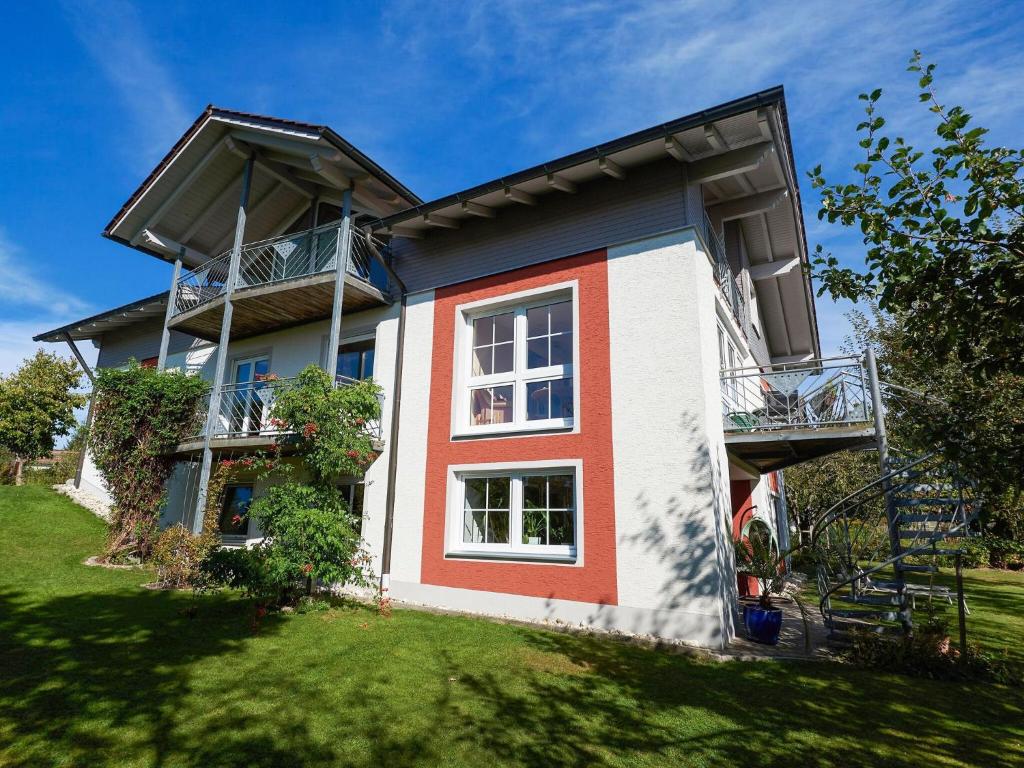 una casa con una fachada roja y blanca en Nice flat with sauna covered terrace garden and tree house for children, en Zandt
