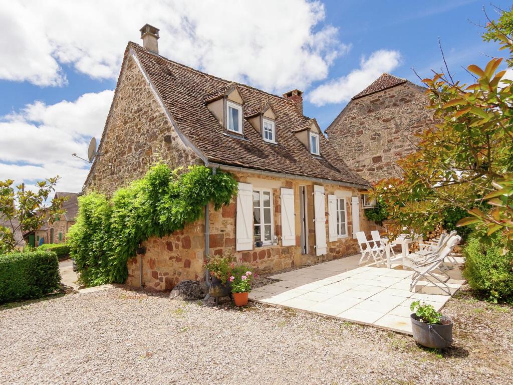 an old stone house with a patio in front of it at Heritage Cottage with Pool in Badefold d Ans in Badefols-dʼAns