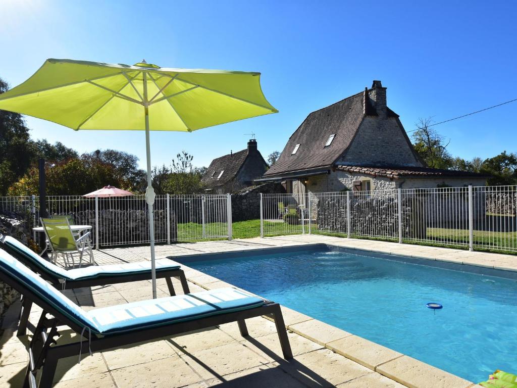 una piscina con sedia, ombrellone e sedia di Modern holiday home with pool in Gramat a Rignac