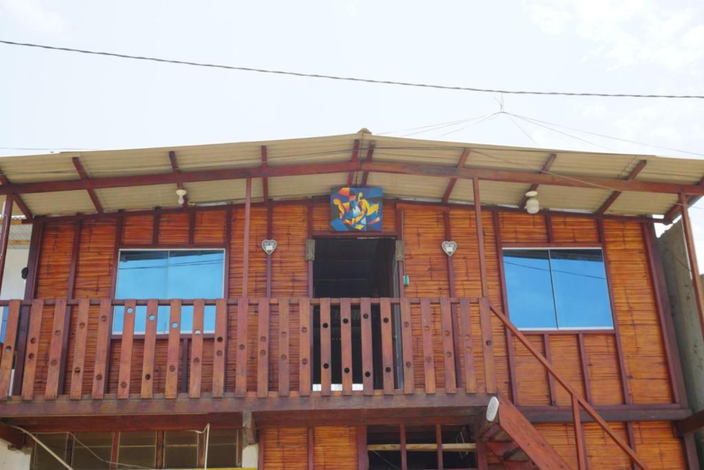 une maison dotée d'une terrasse avec un drapeau. dans l'établissement Hostel Paqaryi, à Zorritos