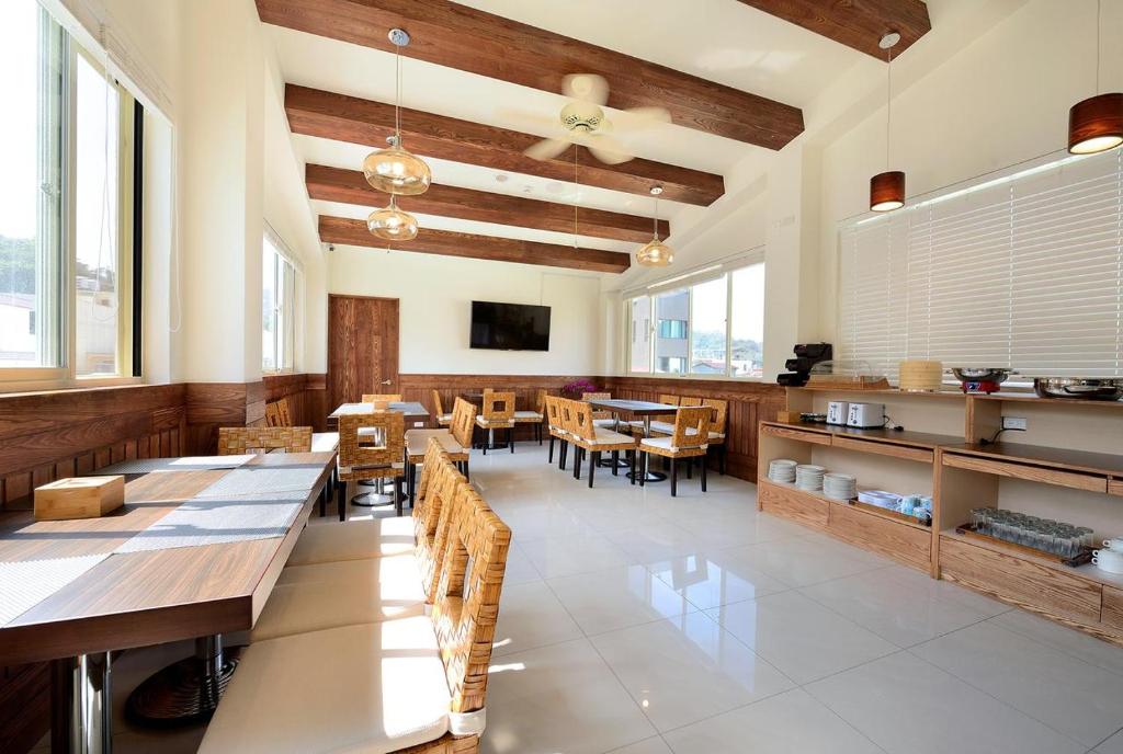 a dining room with tables and chairs and windows at Miller Home in Yuchi