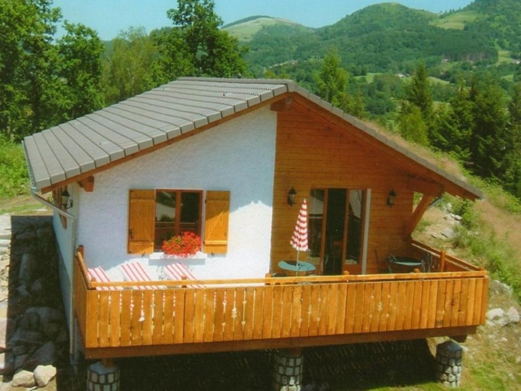 una piccola casa con un ampio ponte in legno di Cozy chalet with a dishwasher, in the High Vosges a Le Ménil