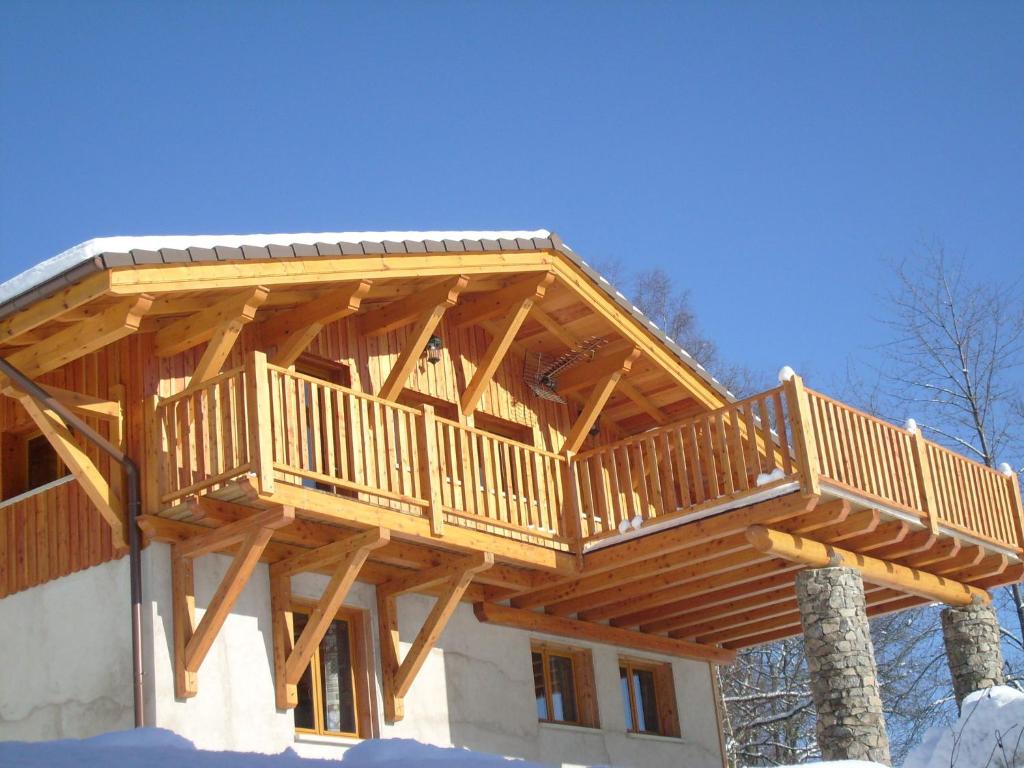 Chalet in Le Thillot with Skiing & Horse Riding Nearby في Le Ménil: سطح خشبي على جانب المنزل