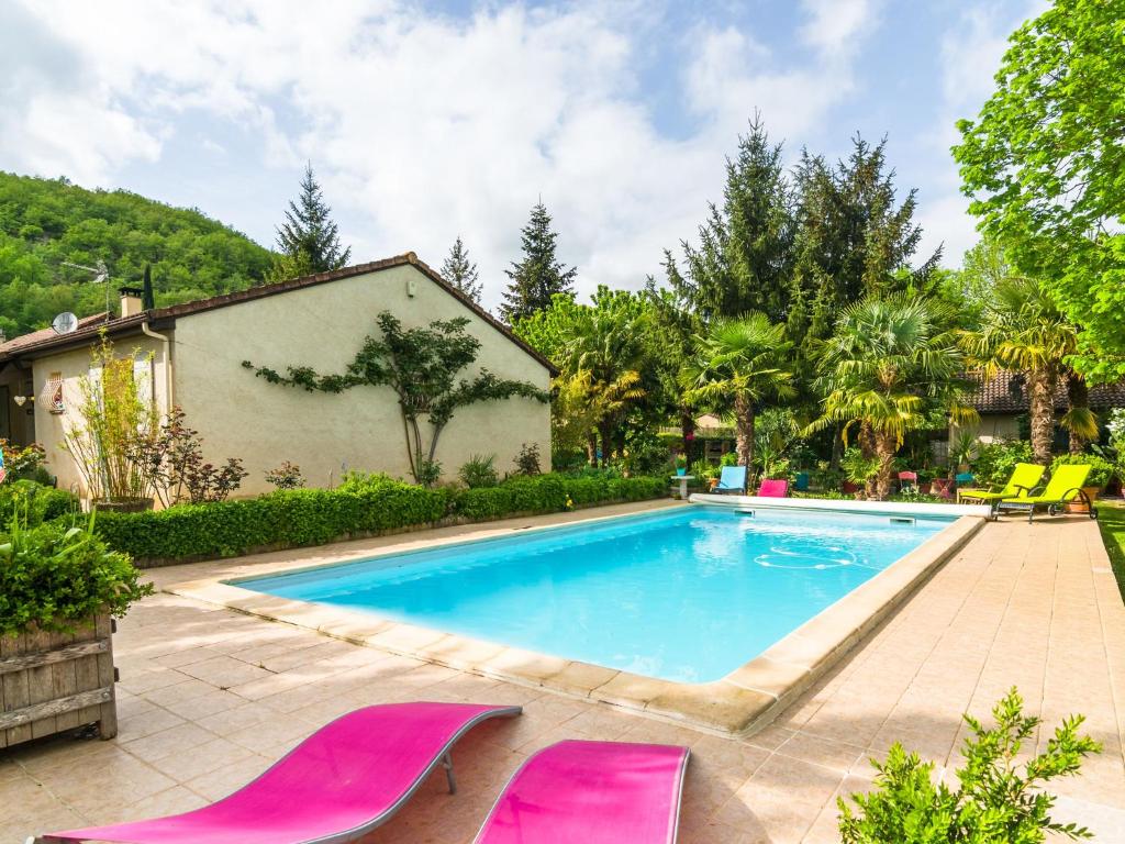 a swimming pool with pink chairs in a yard at Beautiful holiday home with courtyard in Calamane