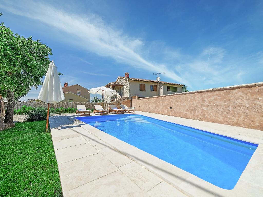 a swimming pool in a yard with an umbrella at Modern Holiday Home in Porec with Swimming Pool in Nova Vas