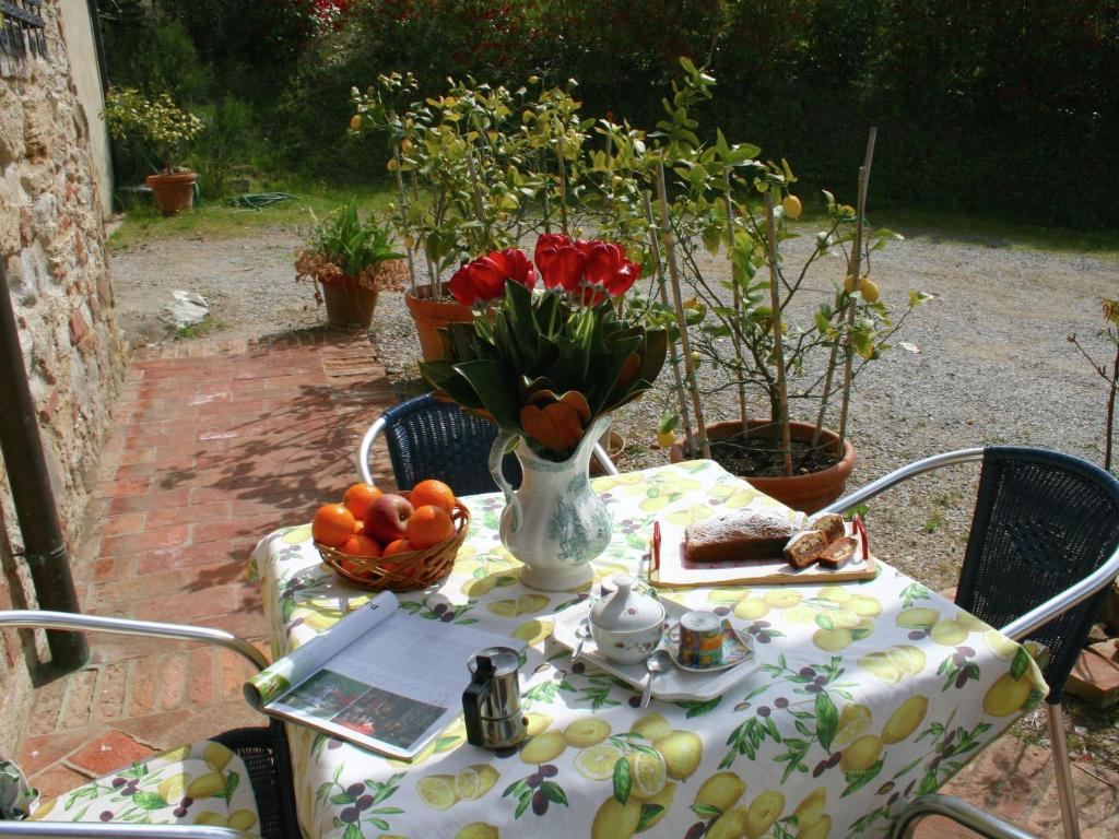 a table with a vase of red tulips and a vase of fruit at Belvilla by OYO Villa Rapolano in Rapolano Terme