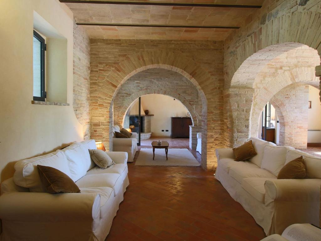 TordandreaにあるBelvilla by OYO Villa Angeliのリビングルーム(白いソファ2台、アーチ付)