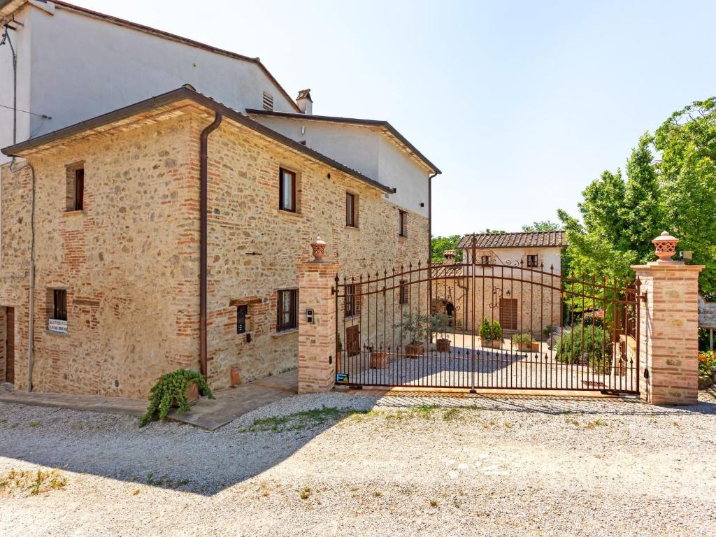 stary ceglany budynek z bramą z kutego żelaza w obiekcie Holiday Home in Umbria with Pool and Views w mieście San Secondo