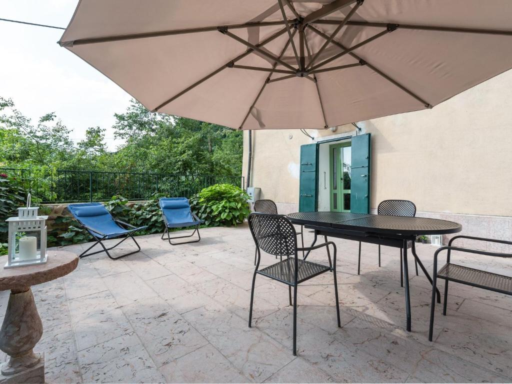 a patio with a table and chairs and an umbrella at Belvilla by OYO Villa Fiorita Due in Romano D'Ezzelino