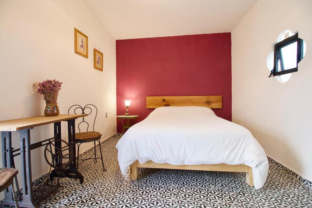 庫埃納瓦卡的住宿－Hermosa Suite Privada en Casa Holística，卧室配有白色的床和红色的墙壁