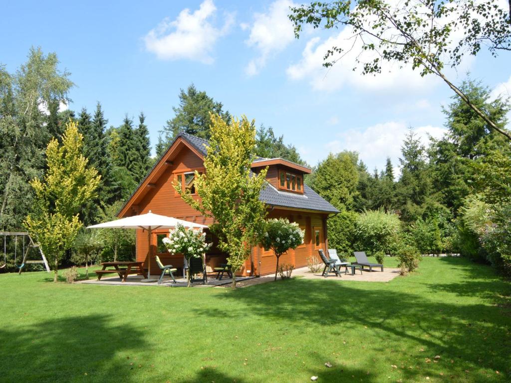 ein Blockhaus mit einem Garten mit Stühlen und Tischen in der Unterkunft Wooden villa on the Veluwe in Wissel