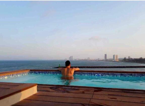 a man in a swimming pool looking at the ocean at FRENTE PLAYA vista al mar, PISCINA DE USO EXCLUSIVO in Boca del Río