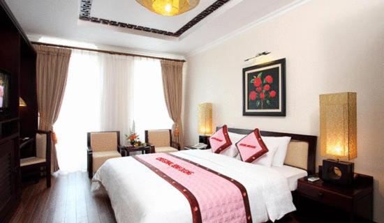 a bedroom with a large white bed with red pillows at Sunny C Hotel in Hue