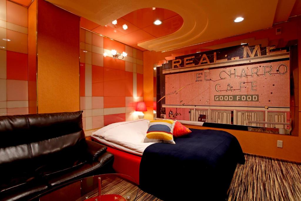Habitación con cama y sofá de cuero. en Hotel Savoy - Adult Only, en Tokio