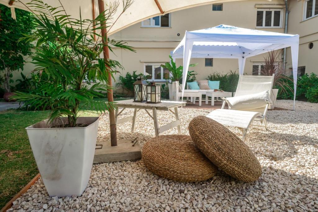 un patio con mesa y sillas y un paraguas en el Hotel Edith de Villa Gesell