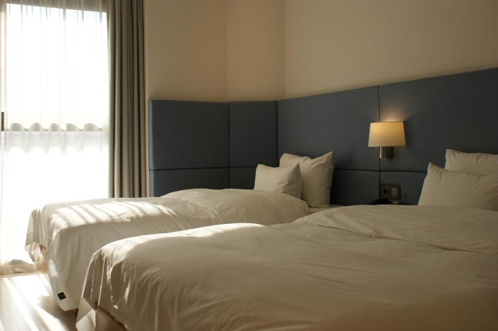 Postel nebo postele na pokoji v ubytování Londoner Hotel Gwangan