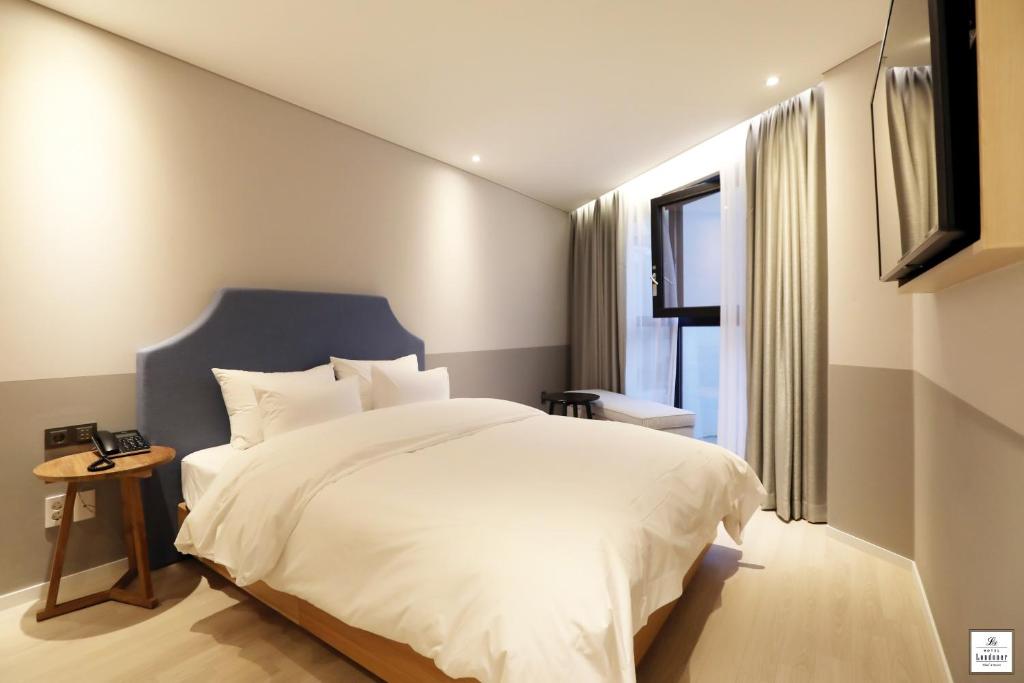 Postel nebo postele na pokoji v ubytování Londoner Hotel Gwangan