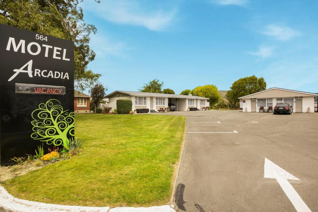 um sinal de Acácia de motel num parque de estacionamento em Arcadia Motel em Christchurch