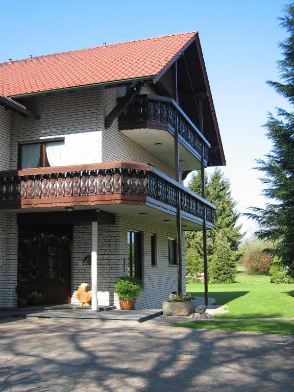 a house with a balcony on top of it at Landhaus Hotel Göke in Hövelhof