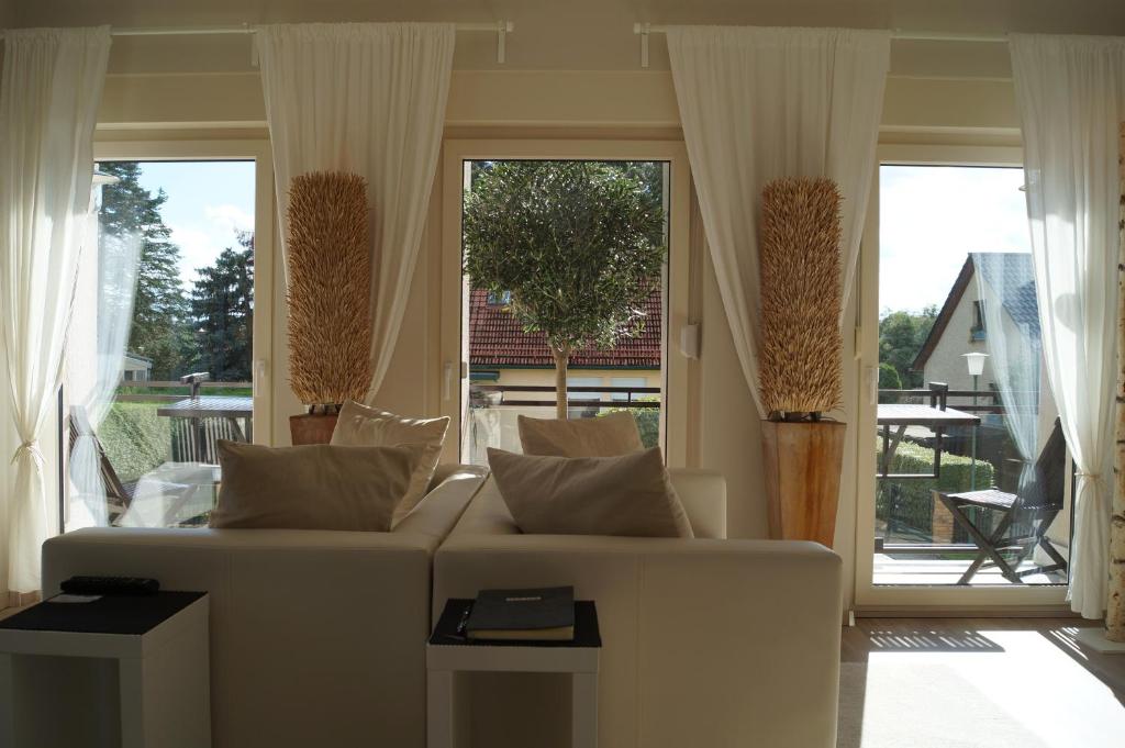 a living room with a white couch and large windows at Haus am See in Storkow