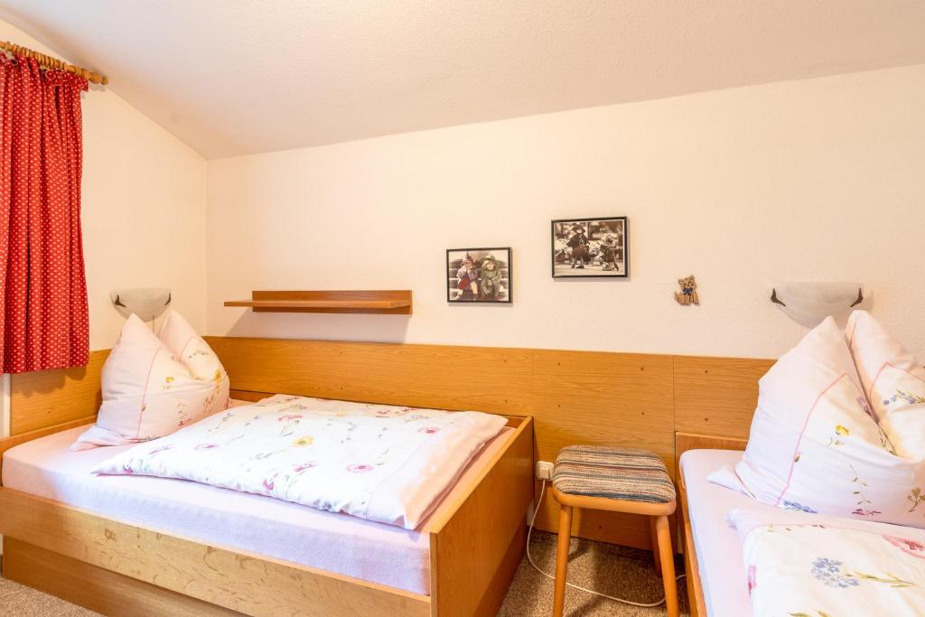 een slaapkamer met 2 bedden en een stoel bij Haus Starlet in Oberstdorf