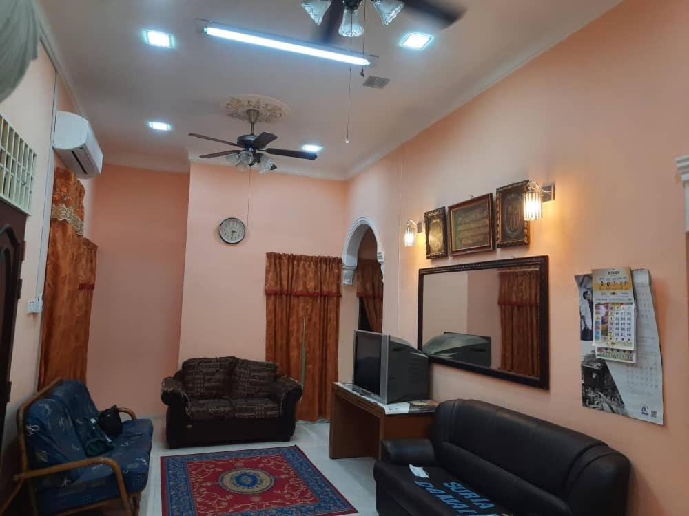 sala de estar con sofá y TV en Suria Damai Homestay, en Pasir Puteh