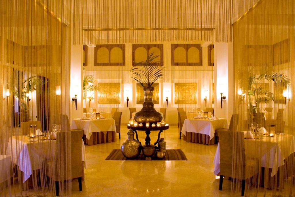 un restaurante con mesas y sillas y una pieza central en una habitación en Baraza Resort and Spa Zanzibar, en Bwejuu