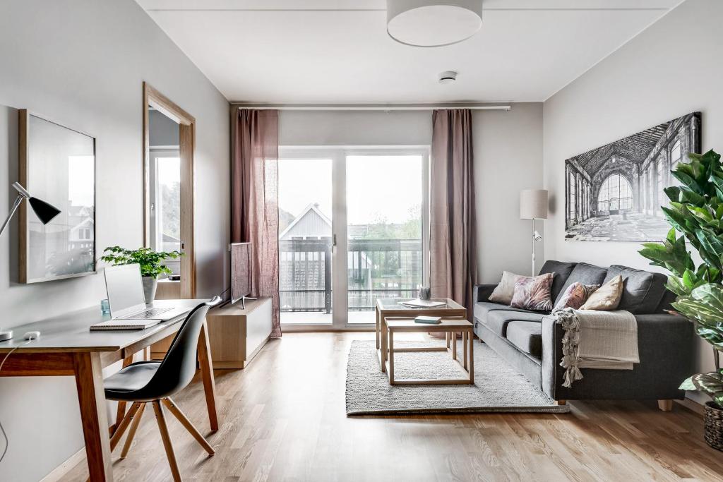 a living room with a couch and a desk at Apartments Mölndal in Gothenburg