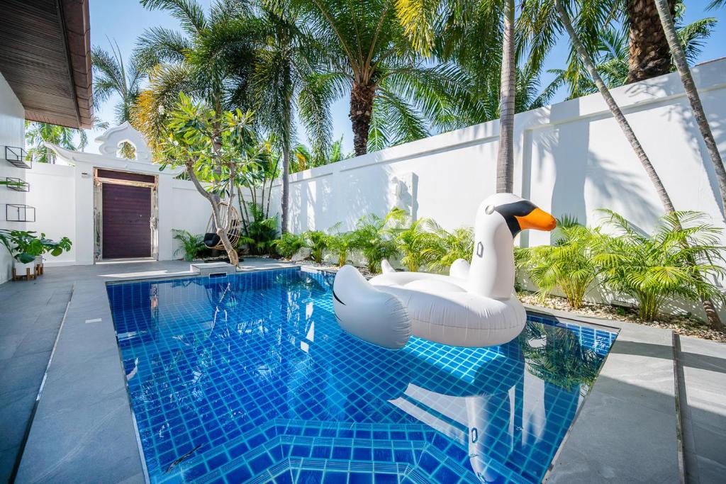 una piscina con un cisne hinchable en una piscina en Majestic Residence Pool Villas 2 Bedrooms Private Beach en Pattaya South