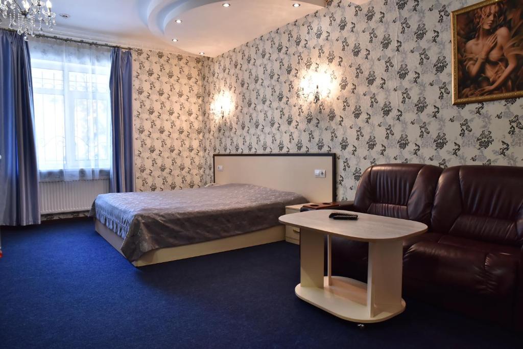 Hotel Т2 في كييف: غرفة نوم بسرير واريكة وطاولة