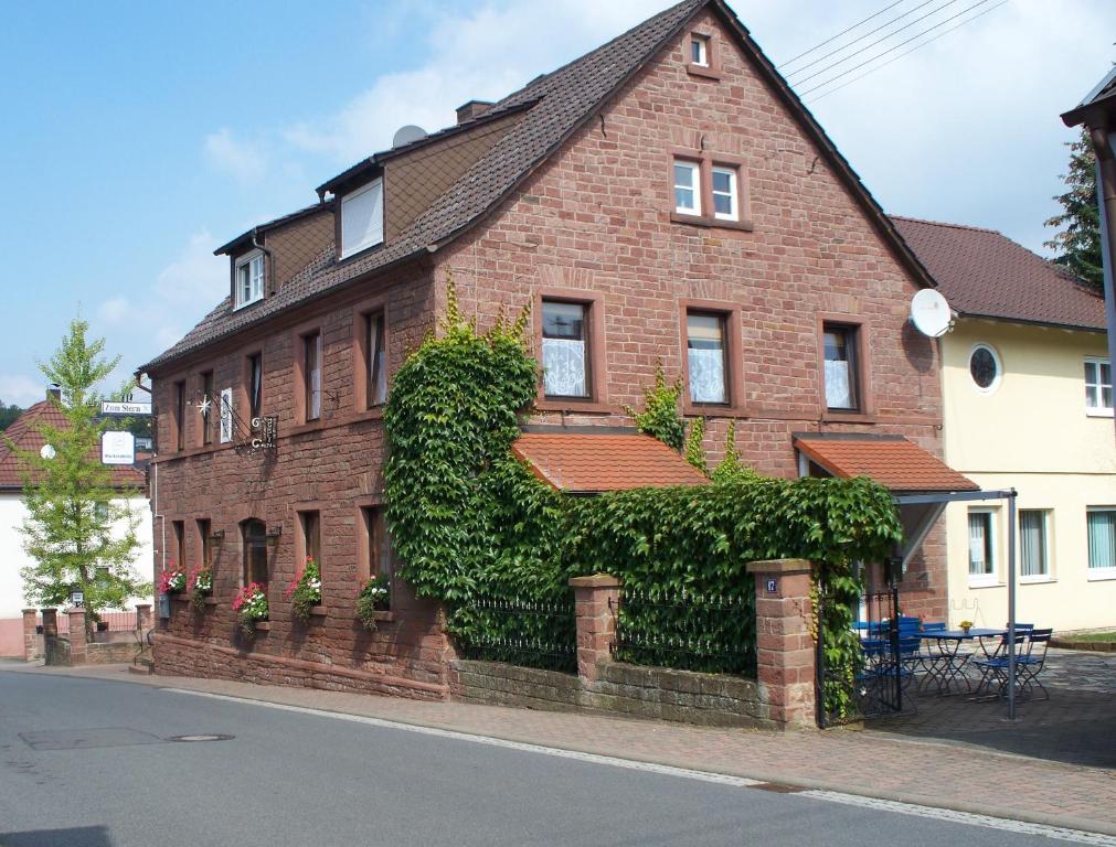 Pension Stern في Rauenberg: منزل من الطوب و ivy على الجانب منه