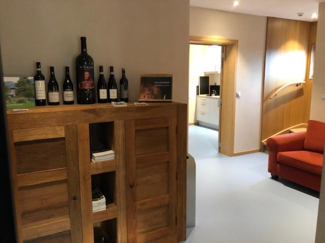 Apparthotel Perreveld في براكيل: غرفة مع زجاجات من النبيذ تجلس على منضدة