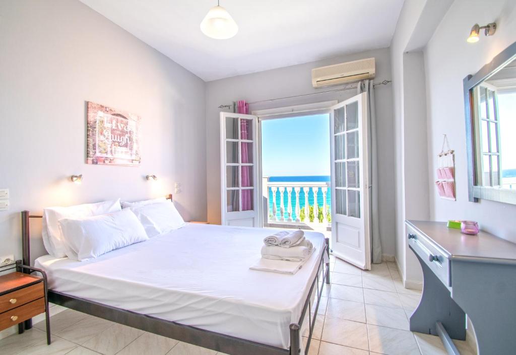 een slaapkamer met een bed en uitzicht op de oceaan bij Bellezza Del Mare in Amoudi