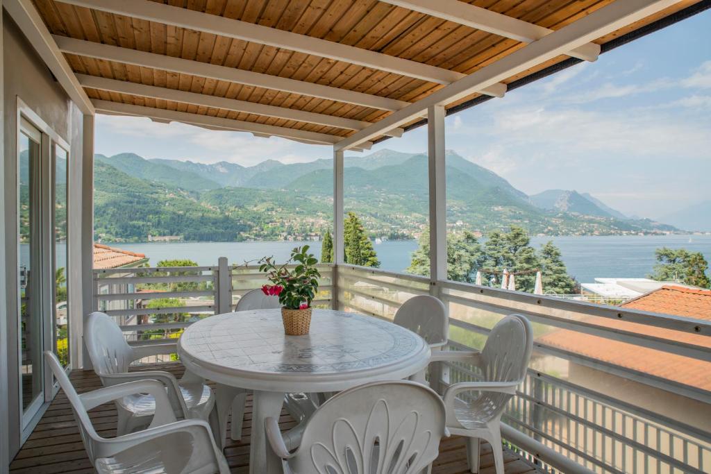 d'une table et de chaises sur un balcon avec vue sur l'eau. dans l'établissement Villaggio Turistico Internazionale Eden, à San Felice del Benaco