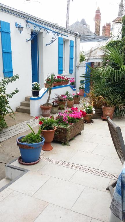 eine Terrasse mit Topfpflanzen vor einem Haus in der Unterkunft Les Volets Bleus in Pornic