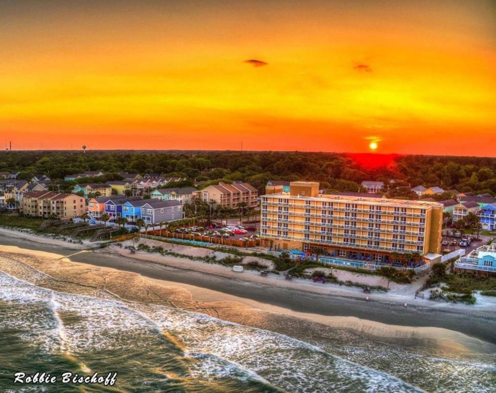 默特爾海灘的住宿－Holiday Inn Resort Oceanfront at Surfside Beach, an IHG Hotel，日落时分海滩上度假村的空中景致