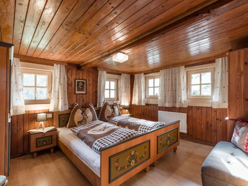 a bedroom with a bed in a room with wooden walls at s´Brunnhäusl in Kelchsau