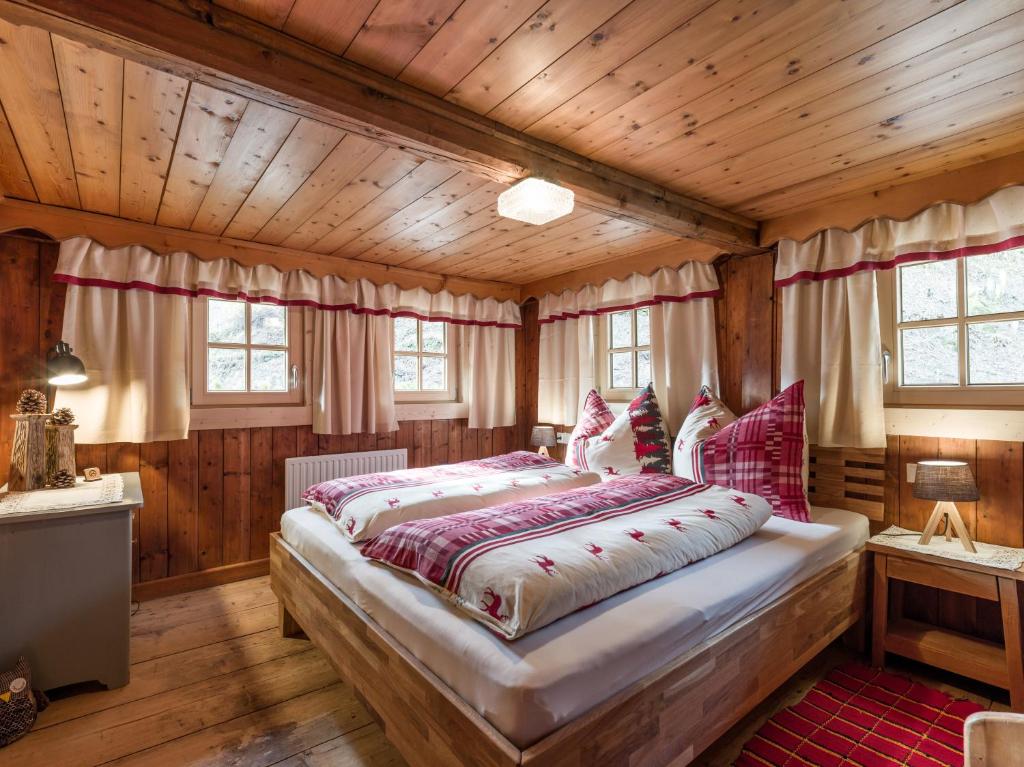 a bedroom with a large bed in a room with wooden walls at s´Brunnhäusl in Kelchsau