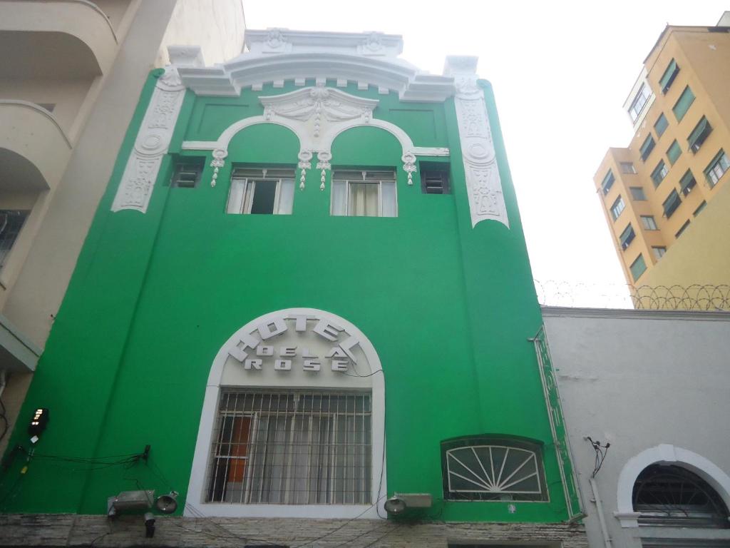 ein grünes Gebäude mit weißer Ausstattung in der Unterkunft Hotel Della Rose in São Paulo